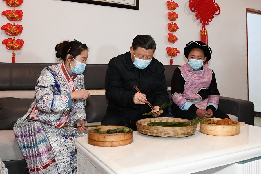 2021年2月3日下午，習(xí)近平在貴州畢節(jié)市黔西縣新仁苗族鄉(xiāng)化屋村苗族村民趙玉學(xué)家，同一家人邊聊家常邊制作當(dāng)?shù)貍鹘y(tǒng)節(jié)日食品黃粑。新華社記者 李學(xué)仁 攝